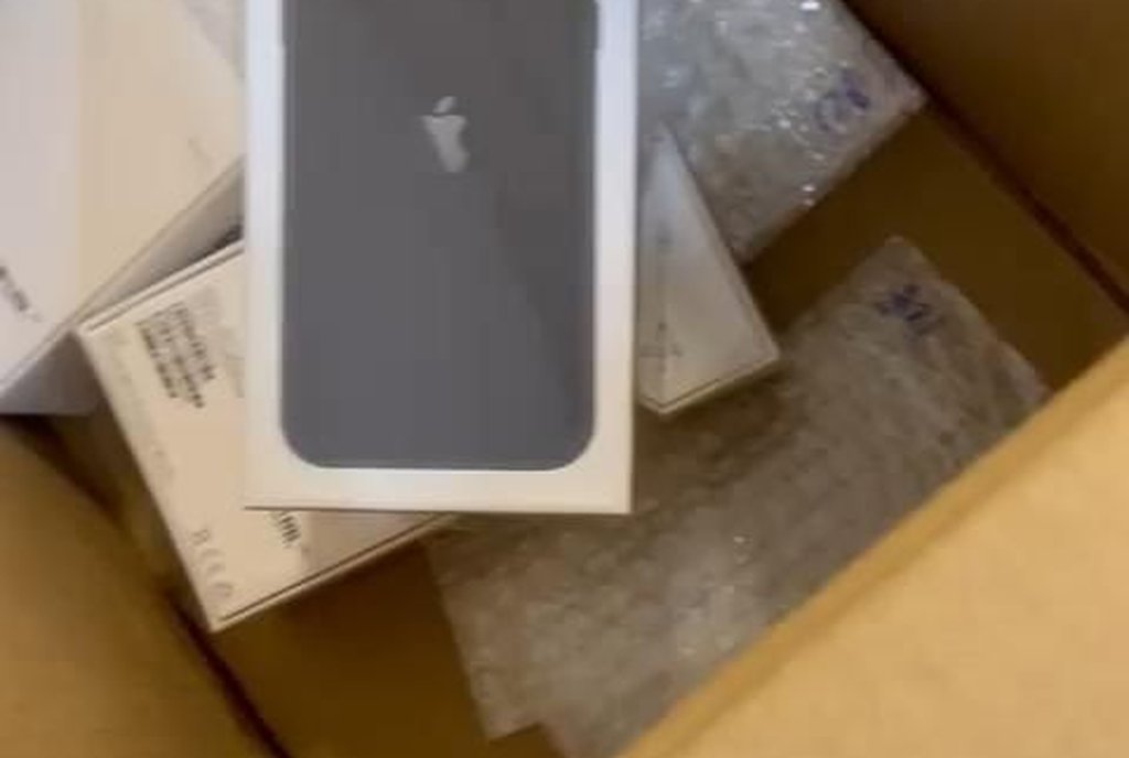 Caixa de papelão com um celular lacrado embrulhado em plástico