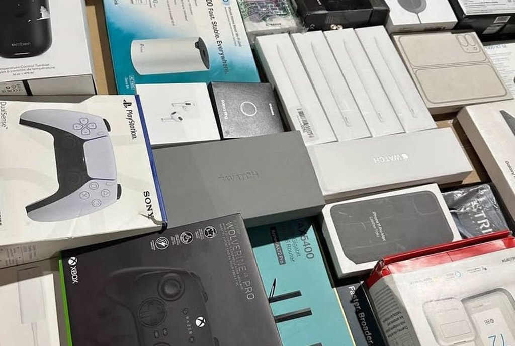 Caixa de papelão com tablet, fones, controle de videogame e acessórios eletrônicos lacrados